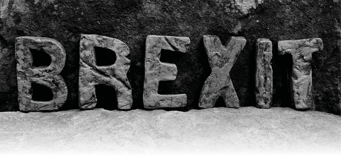 The Word  Brexit  on the Rocks, Showing the Rough Texture of the Letters on a Light Natural Stone Shelf 