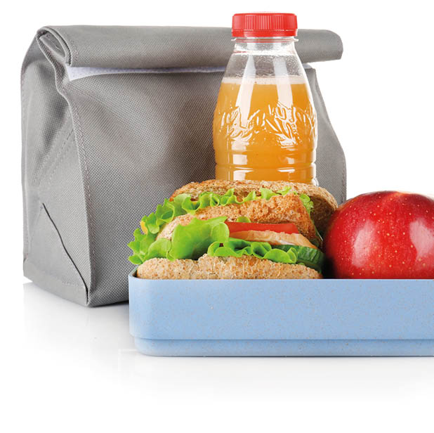 Lunch box and bag with food and stationery on white background