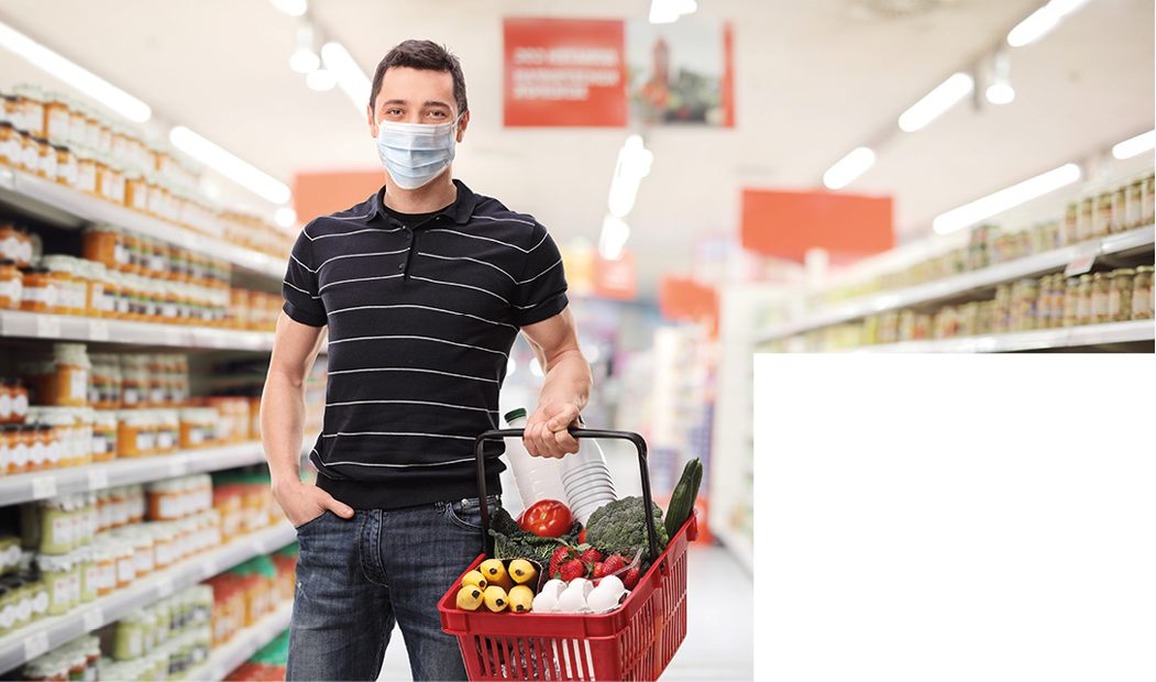 Young man with a medical mask and a shopping basket in a supermarket