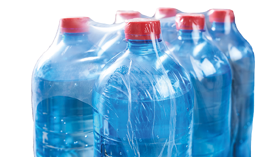 Plastic bottles water in wrapped package on black background 