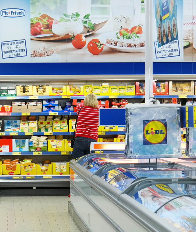 MALMEDY, BELGIUM - JULY 29, 2015: Interior of a Lidl supermarket  Shopper in the refrigerated fresh products aisle  Lidl is a German discount chain, 9800 stores, in 28 countries in Europe 