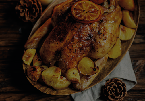 Roasted turkey or chicken with orange slices and potatos in plate for Christmas dinner served with festive decoration on rustic background 