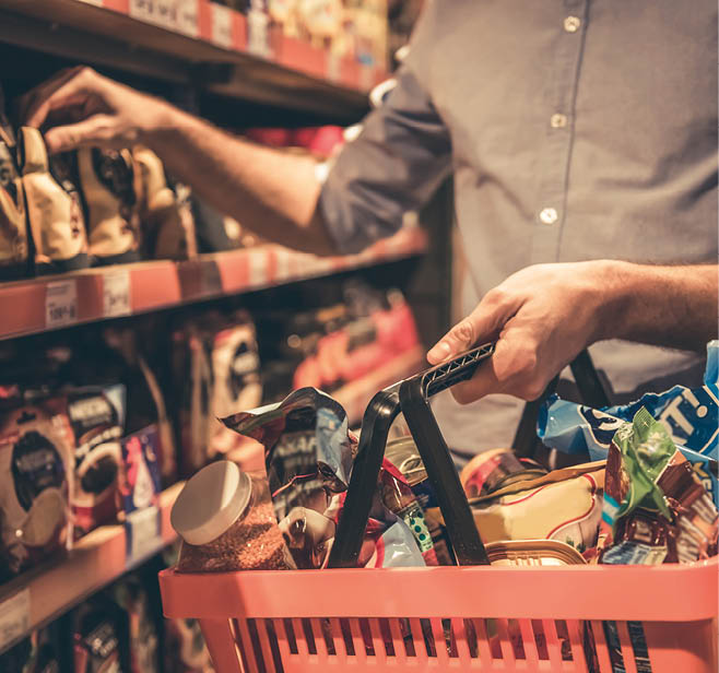 Cropped image of handsome man with a market basket doing shopping at the supermarket