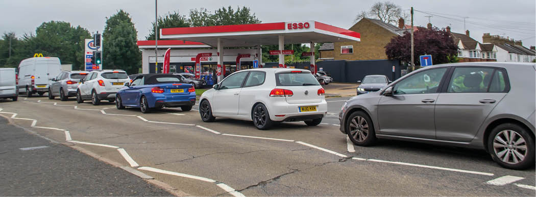 DENHAM, ENGLAND - 25 September 2021: Queue of cars outside Esso petrol station amid fuel shortage crisis