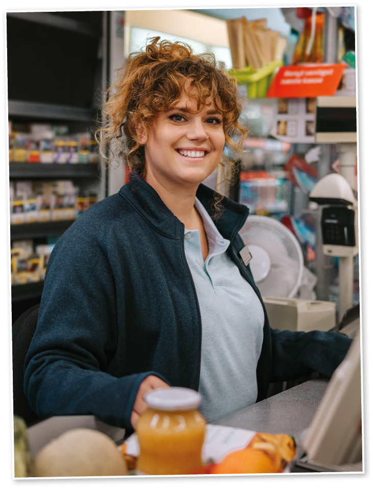 Portrait of a happy woman working at checkout counter smiling at camera  Supermarket employees working at cash register counter 