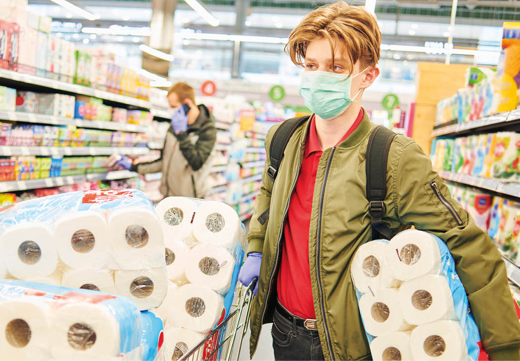 man in mask and protective gloves buying toilet paper in shop  Panic at coronavirus epidemic