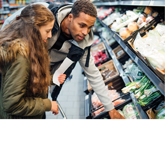 Little girl is buying groceries in the supermarket with her father 