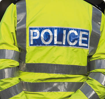 Shot of the back of a police officer's jacket with the word police written across the back