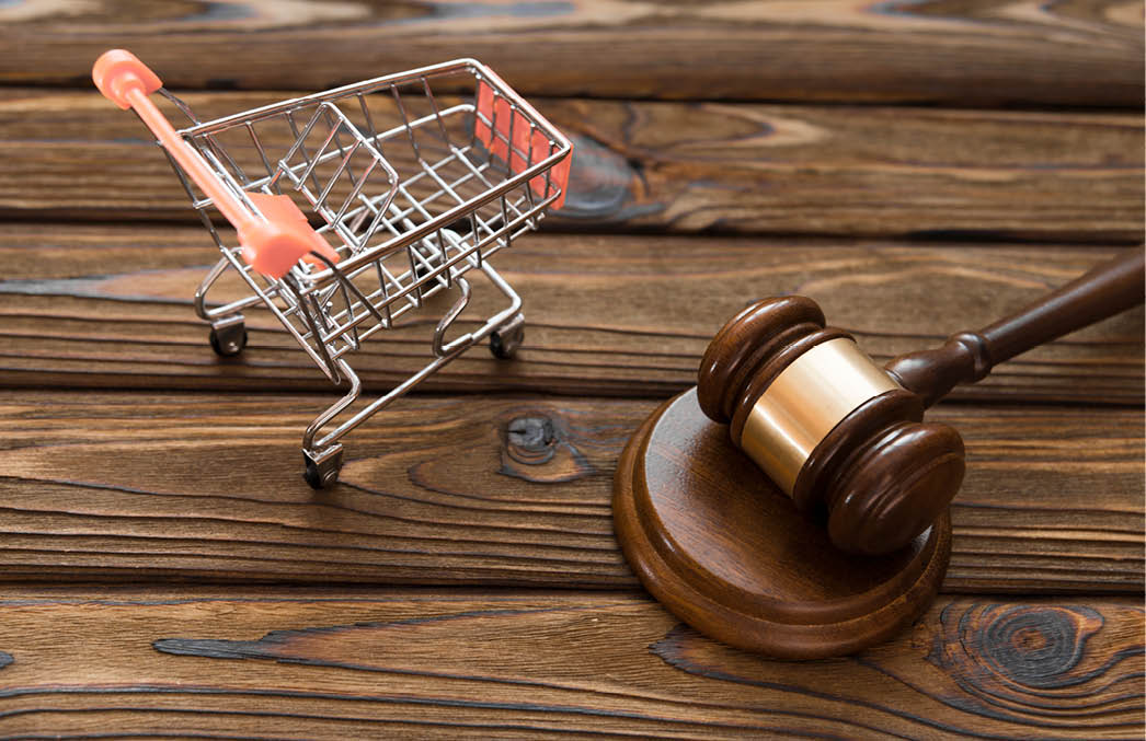 hammer of the judge, a trolley from a supermarket on a wooden background. consumer rights Protection.