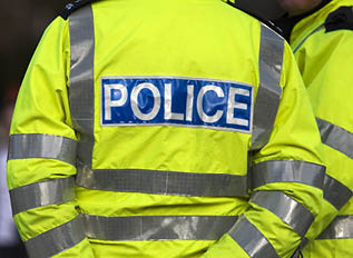 Shot of the back of a police officer's jacket with the word police written across the back