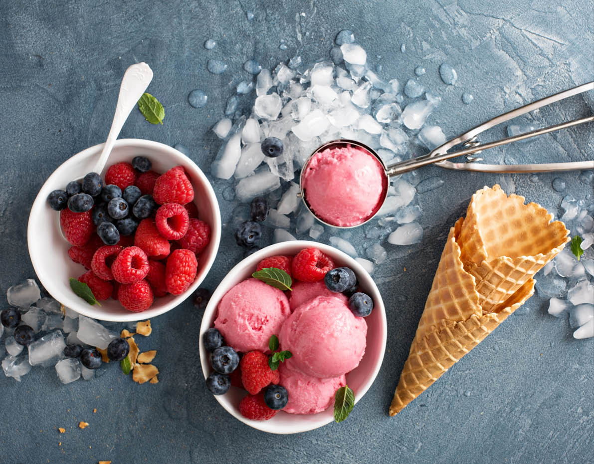Raspberry ice cream in white bowl overhead shot