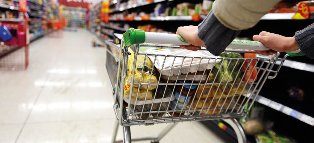 London, UK - August 18, 2014: A shopper pushes a trolley along an aisle in an Asda supermarket. American company Walmart owns Asda, which is UK's largest retail chain after Tesco with 568 stores.