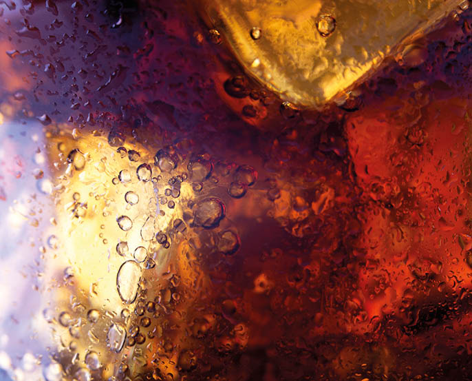 Close up view of the ice cubes in cola background