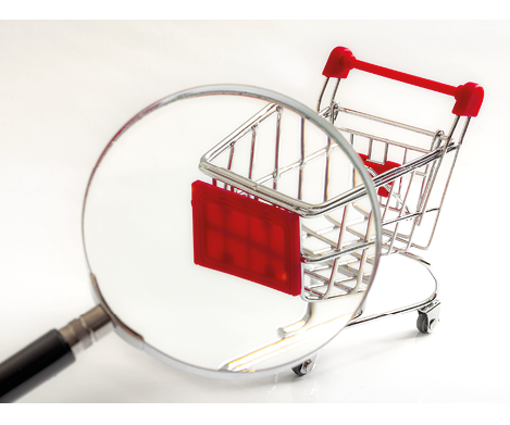 Secret shopper or mystery shopper concept with a magnifying glass and a shopping basket or trolley isolated on a white background and copy space