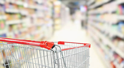 empty red shopping cart in supermarket aisle