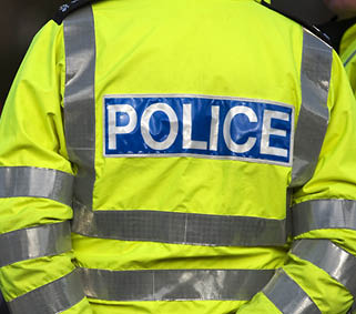 Shot of the back of a police officer's jacket with the word police written across the back