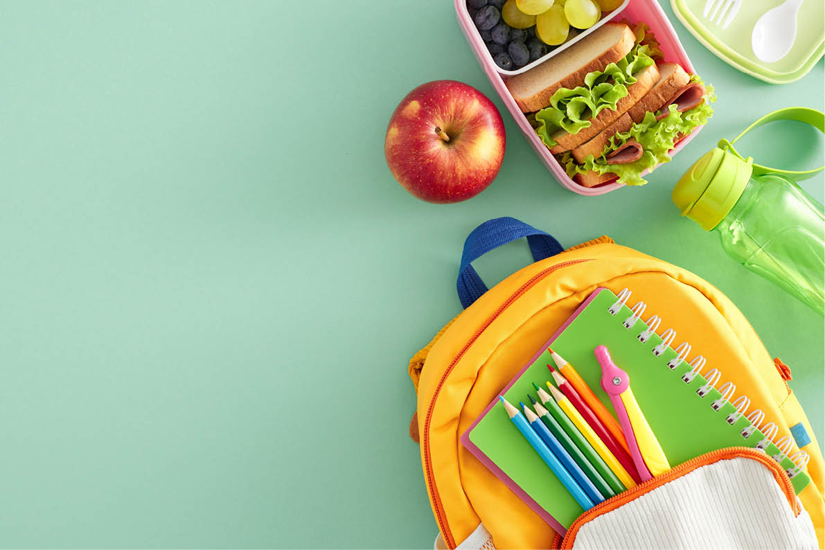 Balanced school meal idea. Top view photo of lunchbox filled with sandwiches and fresh snacks, cutlery, plastic bottle, stationery, rucksack on turquoise background with blank space for advert or text