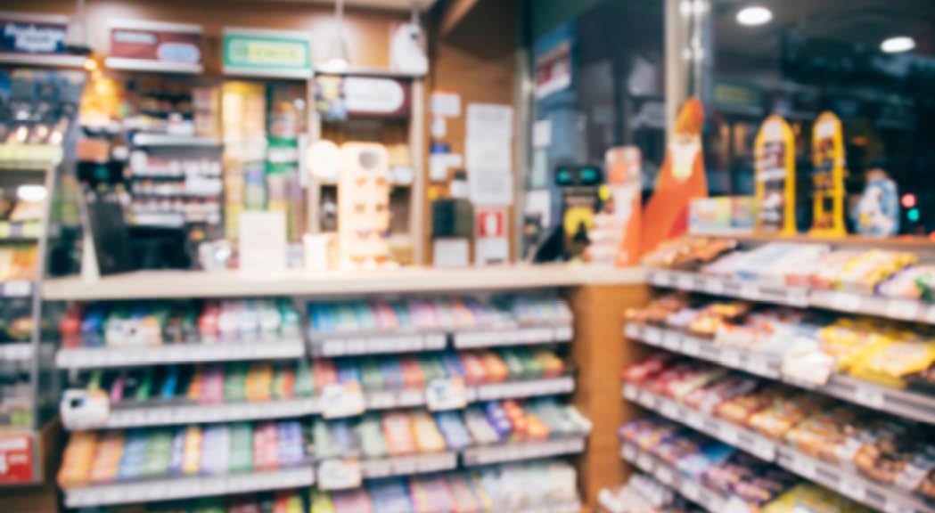 blur photo background of snacks and consumer product colorful in supermarket shop front shelf at counter cashier's desk  Mini-mart convenience stores are a new alternative for the urban people concept