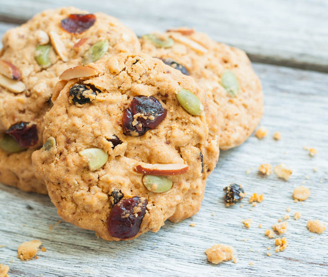 Pumpkin, oat cookies with cranberries, almond on wooden background