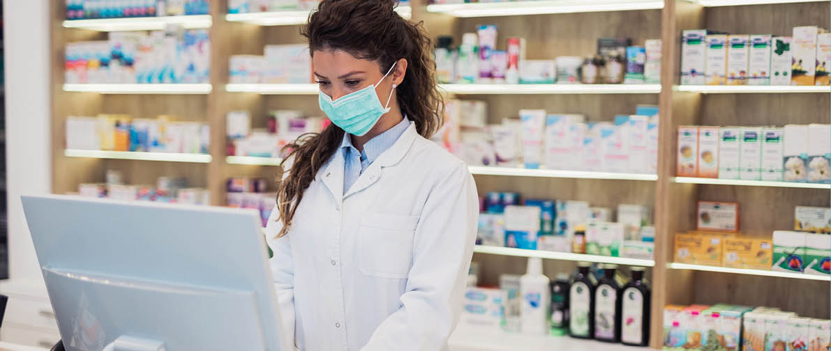 Female pharmacist with protective mask on her face working at pharmacy  Medical healthcare concept 