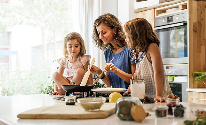 Little sisters cooking with her mother in the kitchen  Infant Chef Concept 
