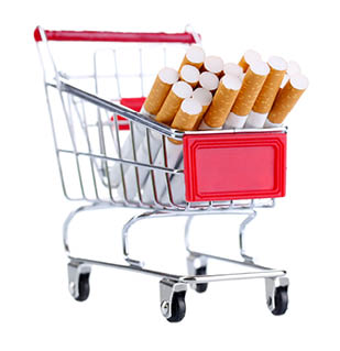 Cigarettes in shopping cart isolated on white