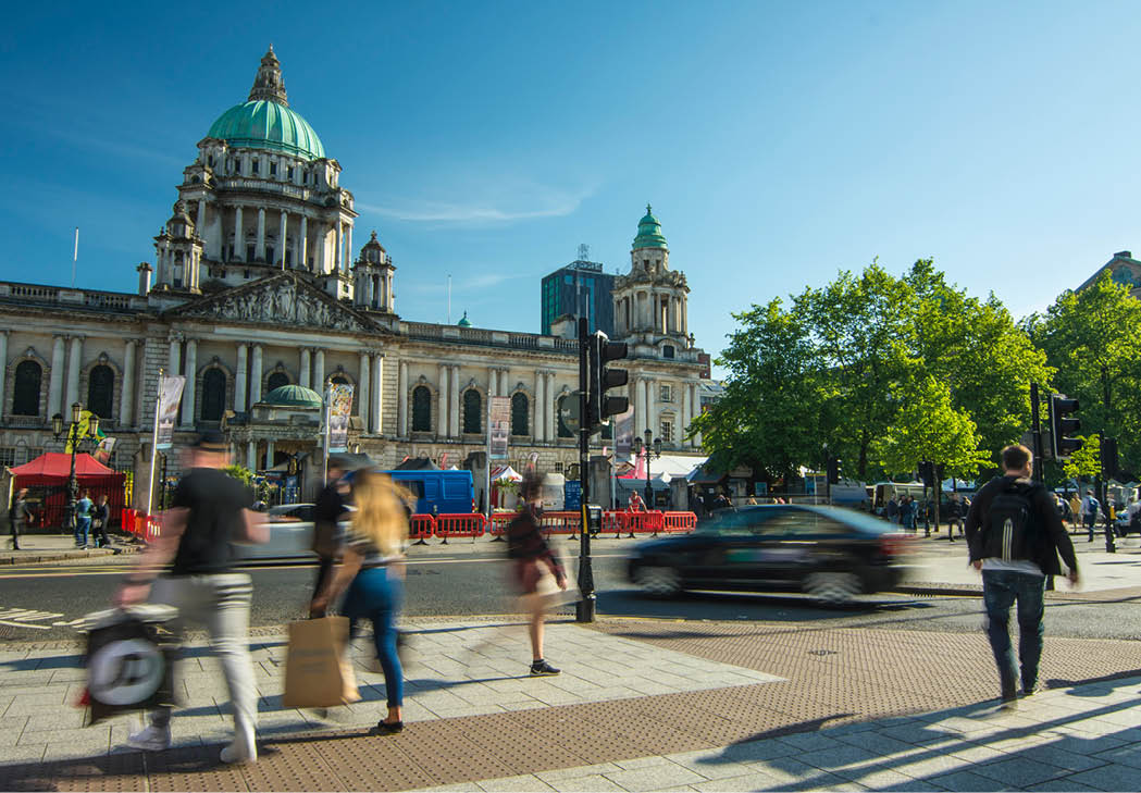 BELFAST, NORTHERN IRELAND- MAY, 2018: Motion blurred people in front of Belfast City Hall on Donegall Square