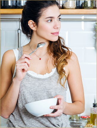 Portrait of beautiful young woman having breakfast in the kitchen.