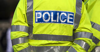 Shot of the back of a police officer's jacket with the word police written across the back