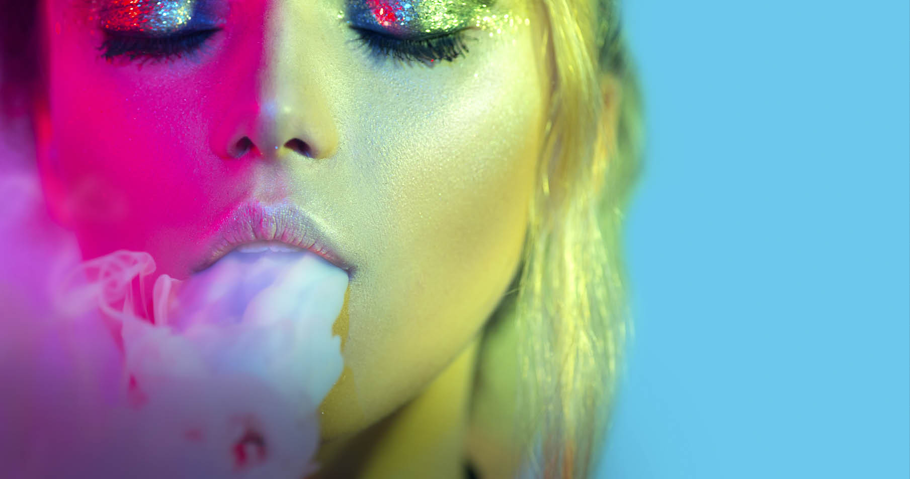 Fashion art portrait of beauty model woman in bright lights with colorful smoke. Smoking girl, Close up of a female inhaling from an electronic cigarette. Night life concept