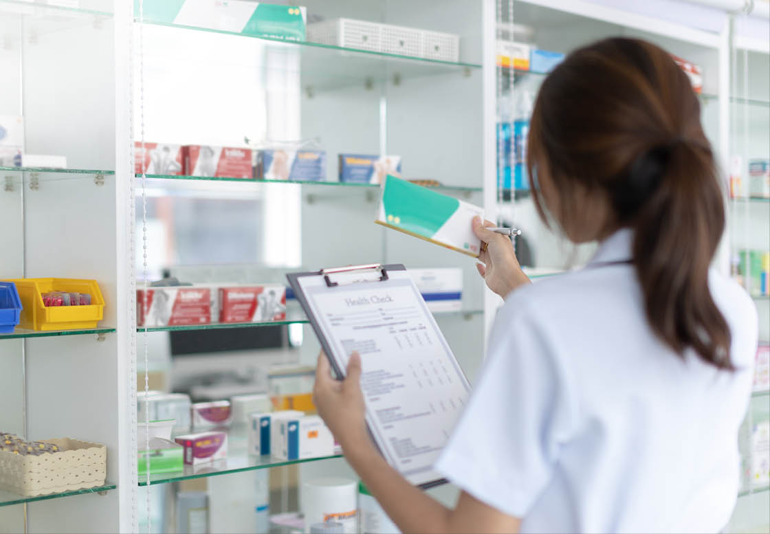 Pharmacist women are supplying prescription drugs to customers, Pharmacists work in a pharmacy, Drug store shelf with prescription medication, Clipboard at the hospital pharmacy, Community Pharmacy.