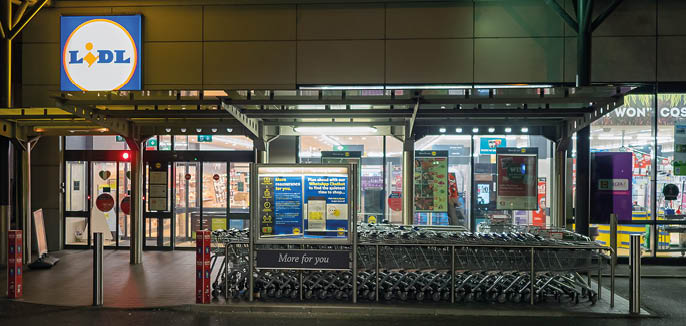 Galway, Ireland - 11.26.2020: Night scene, Entrance to Lidl grocery store on Headford Road. COVID guideline in front, nobody