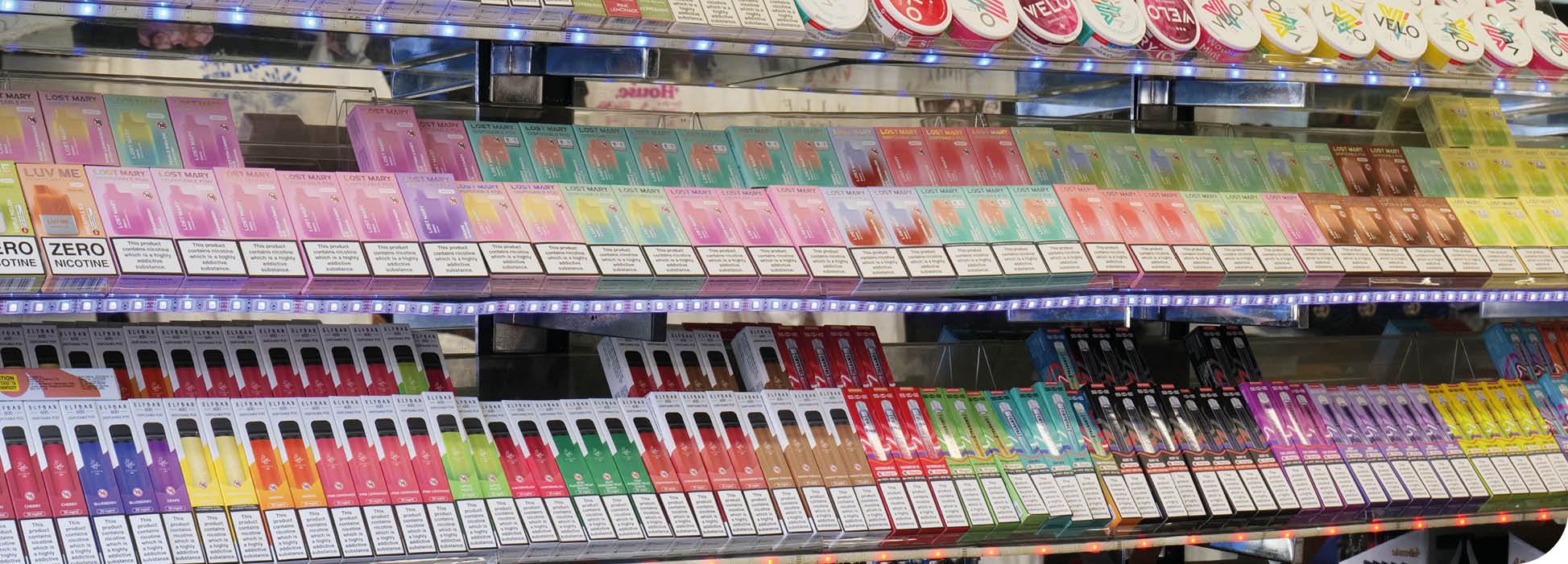 London, UK 08 28 2024 Rows of vibrant disposable electronic cigarette vapes and lighters stacked on shelves in a tourist shop in the city