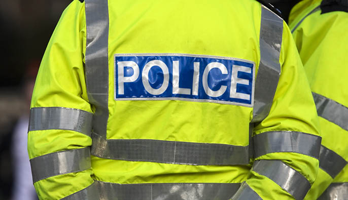 Shot of the back of a police officer's jacket with the word police written across the back