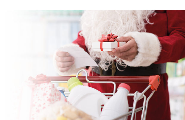 Santa Claus doing grocery shopping at the supermarket, he is pushing a full cart and checking a list, Christmas and shopping concept
