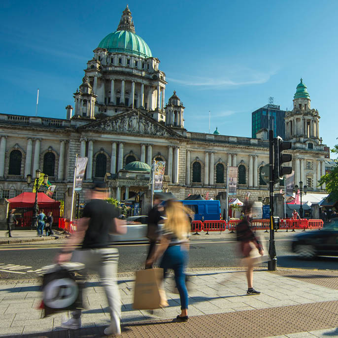 BELFAST, NORTHERN IRELAND- MAY, 2018: Motion blurred people in front of Belfast City Hall on Donegall Square