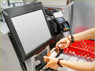 Girl customer scans bottle of wine at the self-service checkout in the grocery supermarket shop