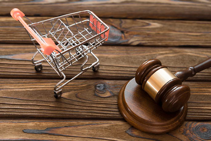 hammer of the judge, a trolley from a supermarket on a wooden background. consumer rights Protection.