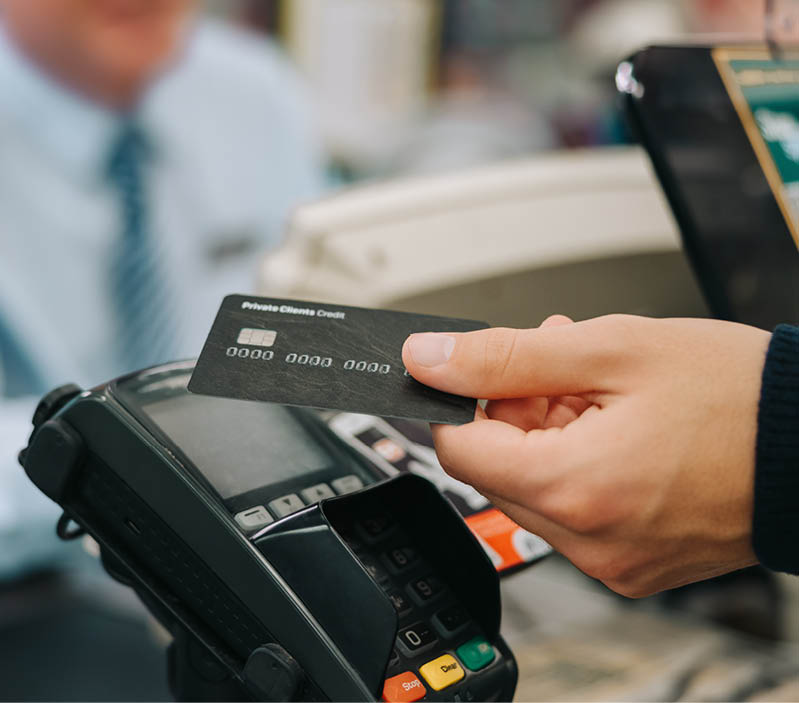 Close-up of a unrecognisable person using credit card to pay at grocery store. Customer making a payment for the purchase using his nfc card at supermarket.