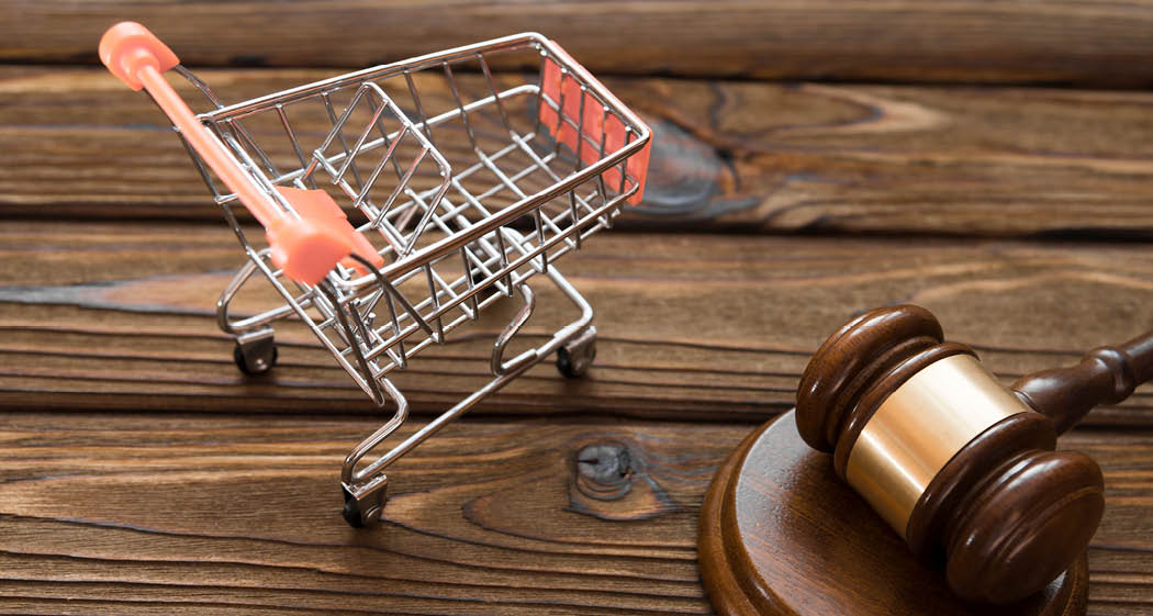 hammer of the judge, a trolley from a supermarket on a wooden background. consumer rights Protection.