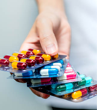 Pharmacist or doctor hand holding pack of antibiotic capsule pills and giving patient or people. Antibiotic drug overuse. Antimicrobial drug resistance. Community pharmacist. Drugstore background.