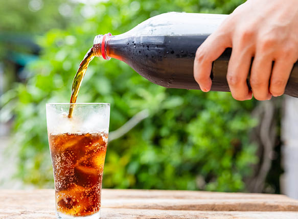 Bottle Pouring Drink In Glass On wooden table in garden