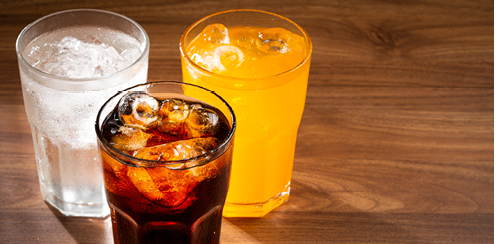 Glasses of soda flavors orange, lemon and cola.