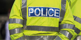 Shot of the back of a police officer's jacket with the word police written across the back