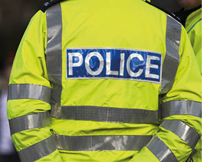 Shot of the back of a police officer's jacket with the word police written across the back