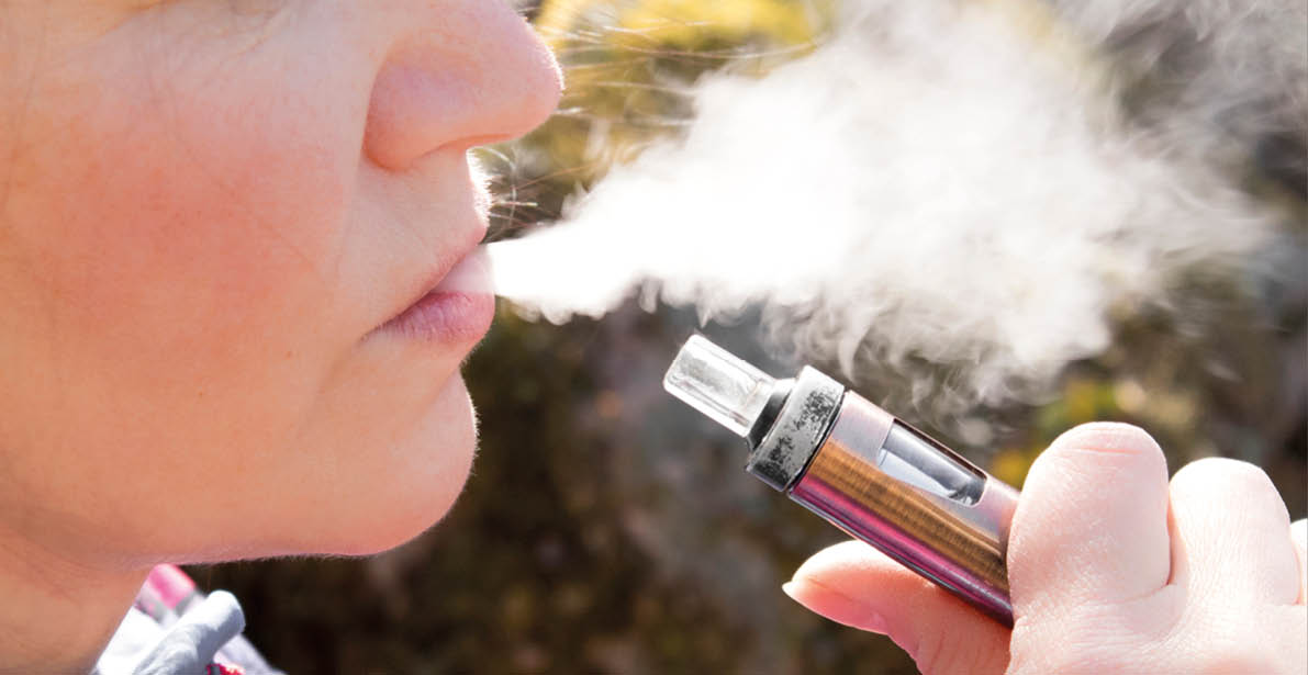 Close-up of a middle age woman smoking an electronic cigarette.