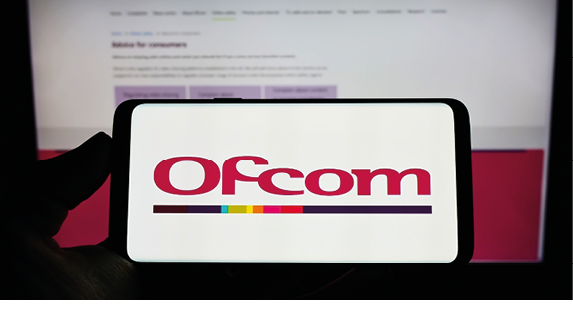 Stuttgart, Germany - 06-04-2022: Person holding cellphone with logo of British authority Office of Communications (Ofcom) on screen in front of webpage. Focus on phone display. Unmodified photo.
