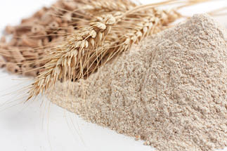 Wholemeal wheat flour and ears of wheat, closeup