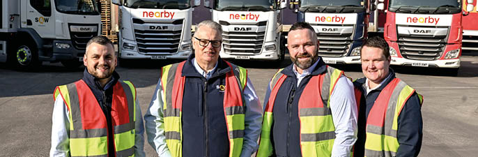Four men wearing safety vests pose in front of several trucks. AI generated content