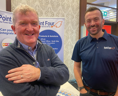 Two men are standing next to a table with a sign on it. AI generated content